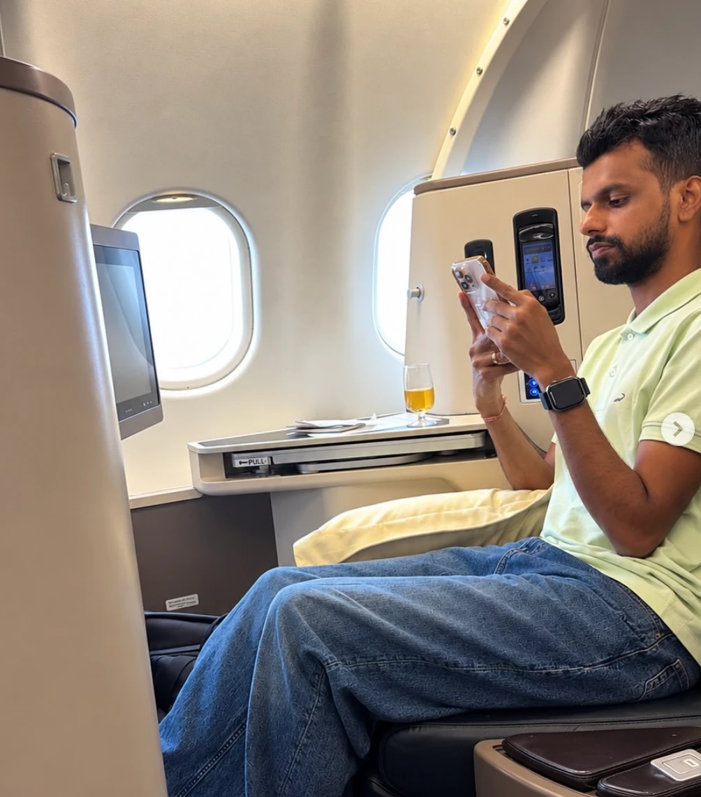 Dulanjaya in an aeroplane seat looking at a phone